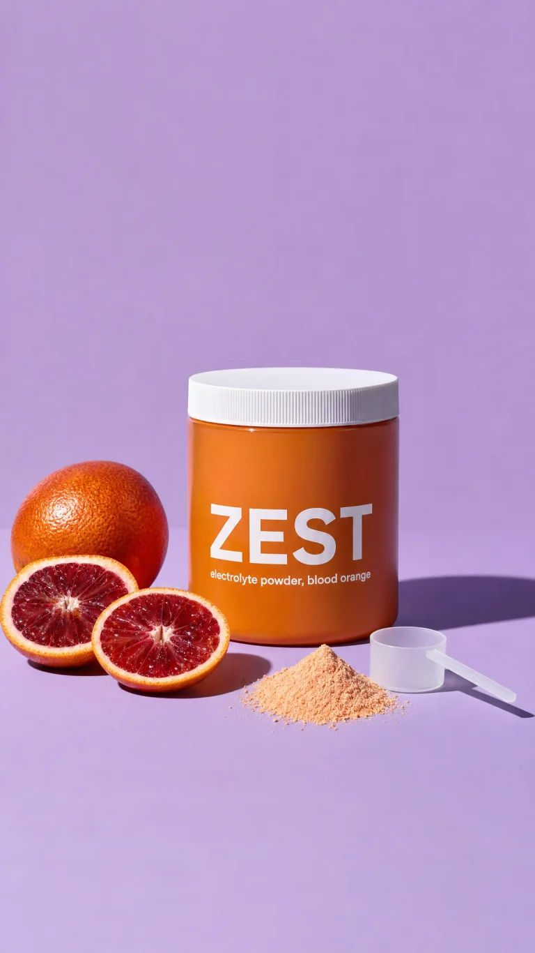 An electrolyte tub beside cut blood oranges on lilac